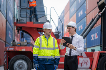 Businessman and Technician team working planning the transportation for import or export at overseas shipping container yard.