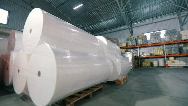 Large warehouse in a nonwovens factory. Industrial interior. Large modern warehouse in the factory. Lots of big rolls of spunbond. Warehouse with rolls of nonwovens.