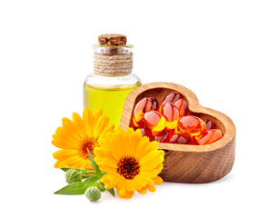 Vitamin capsules with calendula flowers and oil.