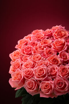 赤い背景にピンクのバラの花束