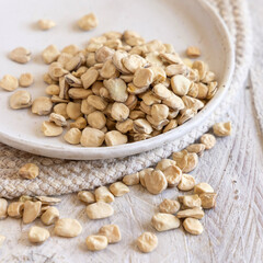 Plate of raw dry Grass pea close up on wooden table. Legumes known in Italy as Cicerchia