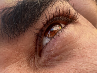 Closeup shot of a glowing brown male eye 