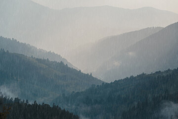 Rain over forest mountains. Mountain range foggy perspective with hills on a rainy day. The Carpathian Mountains. Ukraine.
