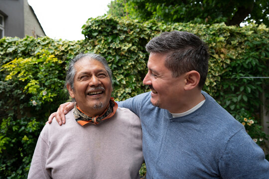 Smiling senior man with adult son outdoors