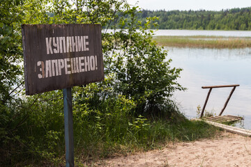 Swimming is prohibited, wooden banner with white Russian text