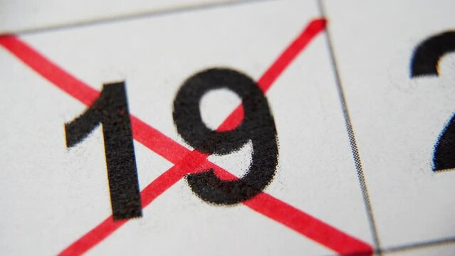 The 19st number in the calendar is crossed out with a red cross in a macro on a white sheet. Calendar for plans, notes, meetings. Business calendar. Marker for notes in the calendar
