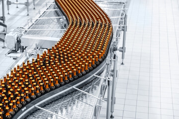 Concept banner brewery plant production line, top view. Glass bottles of beer on dark background