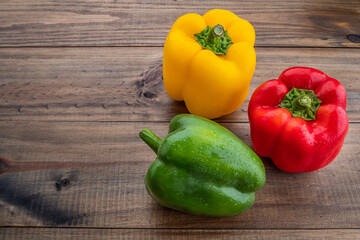 sweet pepper on wood background, paprika, red, green and yellow sweet bell peppers on table
