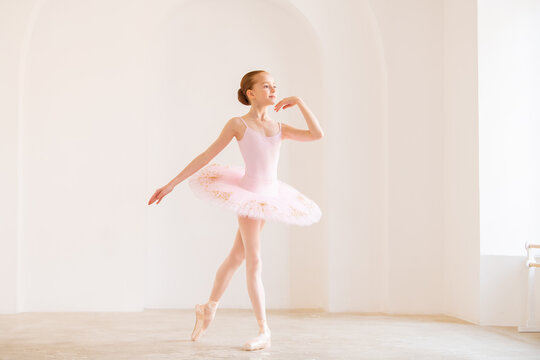 Little girl ballerina dancer in tutu learning ballet dance at dance school