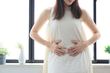 お腹に手を当てる女性