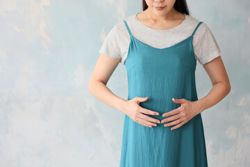 お腹に手を当てる女性