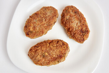 Fried meatballs on a white plate.