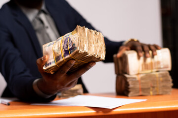 african businessman offering a bundle of cash