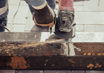 A worker cuts metal at a construction site.