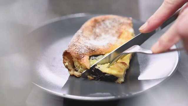 Cutting of freshly prepared traditional french dessert Far Breton.

