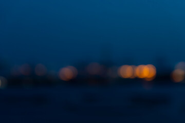 Blurred of industry background with defocused cargo dock terminal in sea with colorful bokeh lights...
