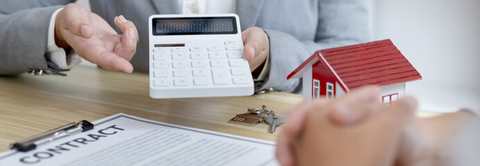 Real estate agent or sales manager talks to clients about the terms of buying a home and collateral...