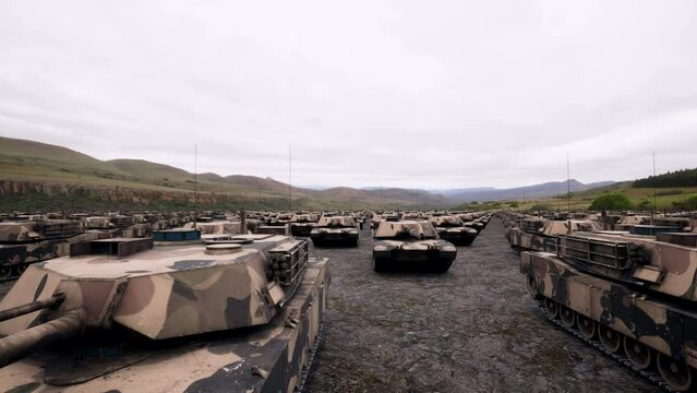 An aerial view over military armored tanks moving in convoy towards the front line of the battlefield.