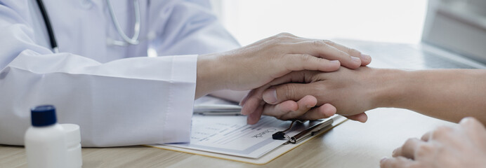 Male doctor specializing in psychiatrist comforts an anxious depression patient for medical treatment in a hospital diagnostic room, Medical treatment and health care concept.