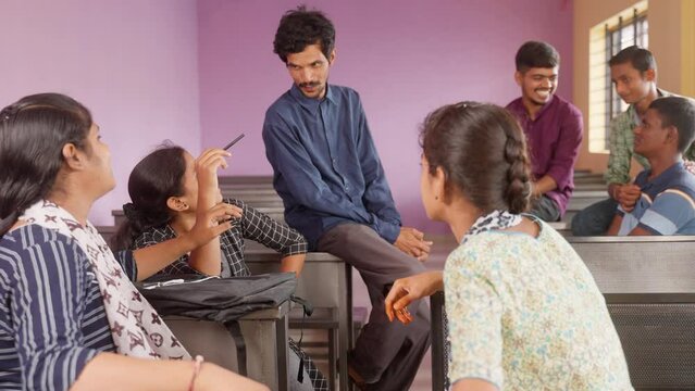 group od Happy smiling college students having chat with each other at classroom during leisure - concept of taking break, friendship and knowledge