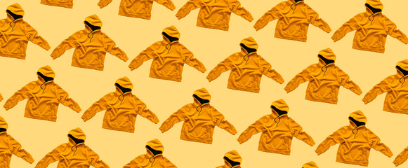 Flying fashionable orange hoodie isolated on yellow background. Stylish unisex jacket, cotton sweater, hoody, hood, autumn clothes. Sweatshirt mockup. creative Hoodie template for design. Pattern
