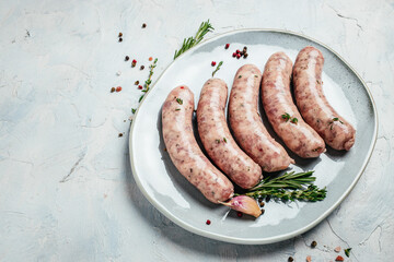 raw sausages with spices and rosemary on plate. Cooking ingredients. Natural healthy food concept....