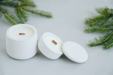 Close-up of Group of White Candles in Concrete Pot of Various Sizes With Lid on Light Background