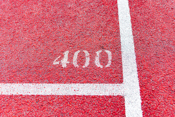 Bright red running track with white line and number 400.Close-up.