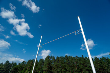 Pole vault against blue sky with sun. Horizontal sport theme poster, greeting cards, headers,...