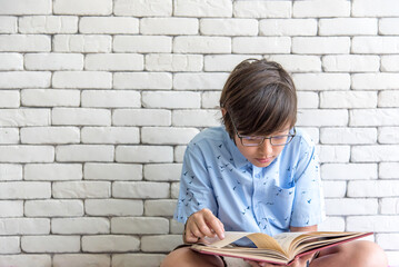 secondary school boy student wearing glasses sit reading book for final exams