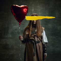 Young woman wearing historical outfit with yellow stroke of paint on her face. Contemporary...