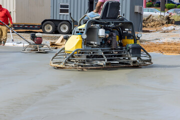 Obraz premium After pouring concrete on the foundation floor, workers are polishing the concrete with concrete polishing machines in construction site