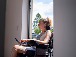 Woman in electric wheelchair going through front door