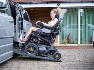 Woman in electric wheelchair getting in van