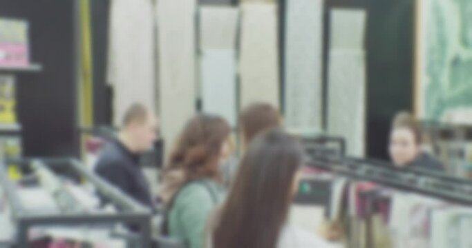 blurred defocused video.customers in a clothing store.silhouettes of unrecognizable people who choose fabrics in the store.