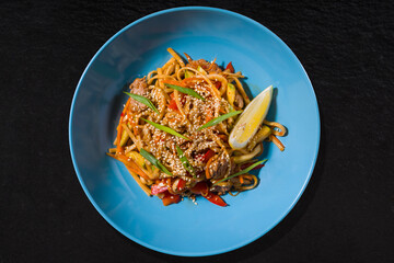 Noodles with sesame seeds, meat, lemon, pepper, carrots