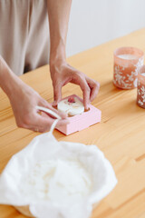 Fototapeta na wymiar Craftsman's Hands Close up. Work Process. Florentine Handmade Sachet Pack in Pink Box.
