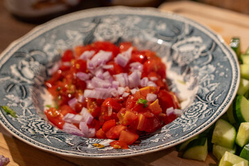 Tomato and onions cut and diced in a blue and white dish
