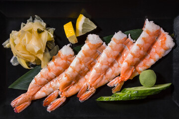 Shrimps on a leaf with cucumber, wasabi, lemon