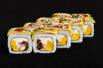 Rolls with avocado, sauce, rice, sesame seeds, cream cheese