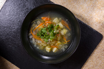Soup plate with potatoes, carrots, parsley