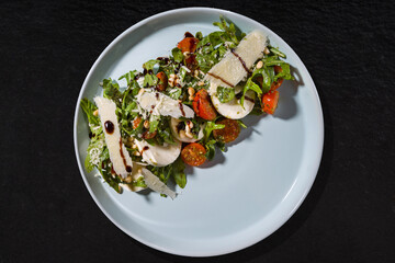 Plate with arugula, grated cheese, feta cheese, sauce, tomato