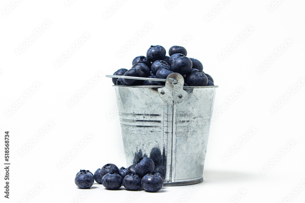 Canvas Prints Blueberries on a white background. Small steel bucket full of blueberries. Useful and tasty berry.