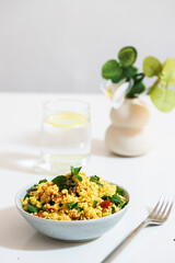 Restaurant table setting with bulgur salad and glass of water on the table. .