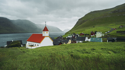 Church and village of Mikladalur, Kalsoy island, Faroe Islands, Denmark. Popular tourist attraction. Travel photo lifestyle.