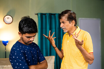 Angry grandfather scolding grandson about his education or behavior at home - concept of...