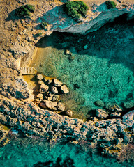 Aerial view of a small hidden cove where you can bathe in crystal clear waters