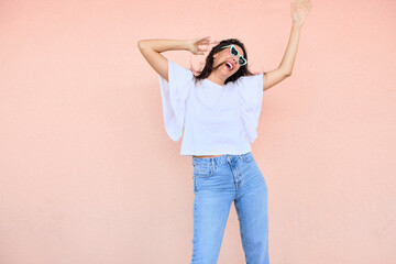happy young woman posing in a fun way with heart shaped sunglasses 