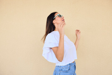 happy young woman posing in a fun way with heart shaped sunglasses 