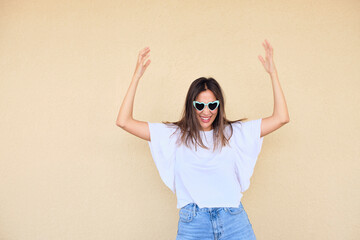happy young woman posing in a fun way with heart shaped sunglasses 